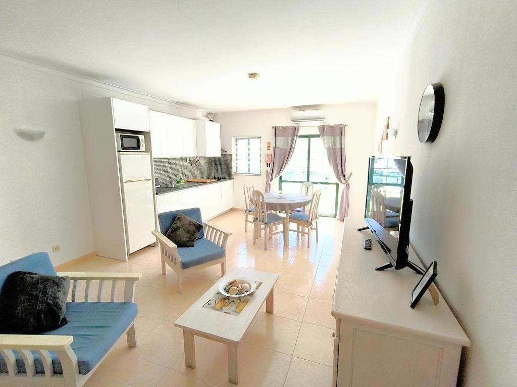 a living room with a couch and chairs and a tv at DUNAS DO ALVOR by LTS Holidays - #127 in Alvor