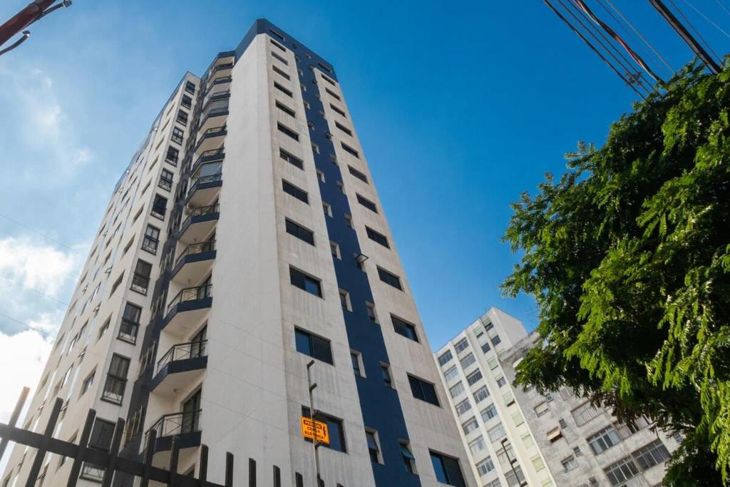 un alto edificio bianco con finestre sul lato di BHomy Avenida a San Paolo