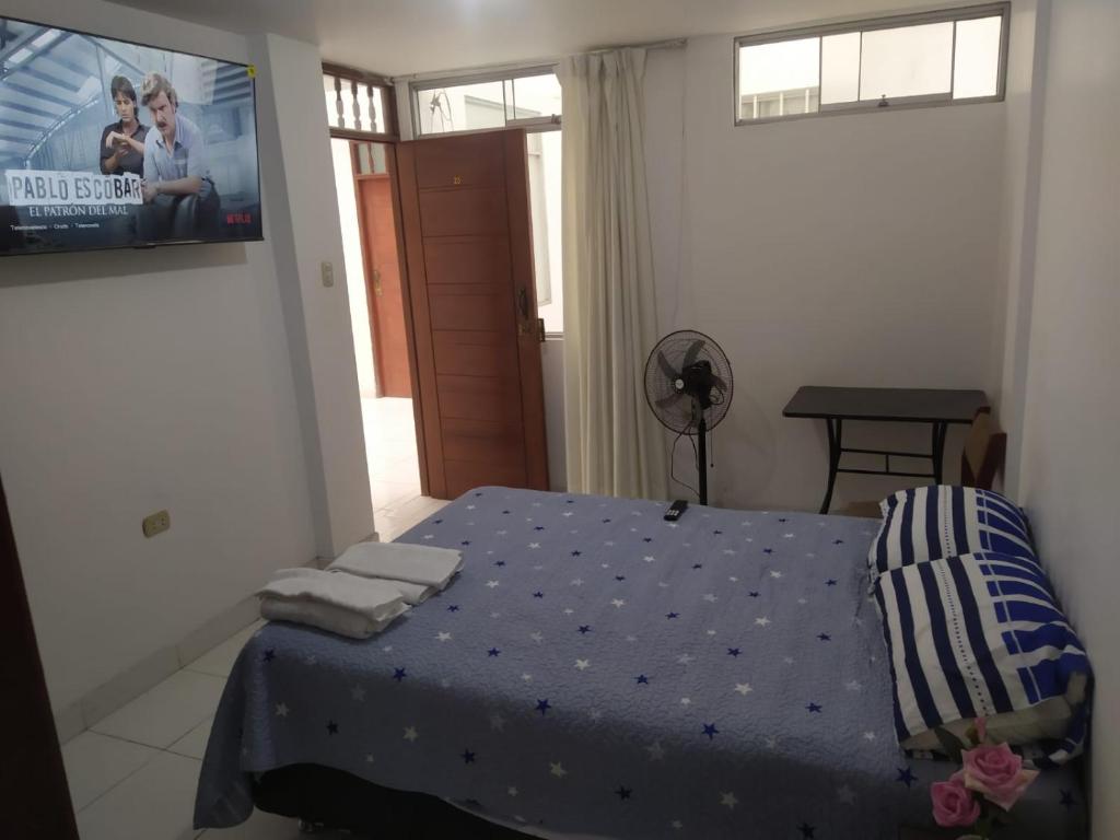 ein Schlafzimmer mit einem Bett und einem TV an der Wand in der Unterkunft Ambigua Hospedaje in Trujillo