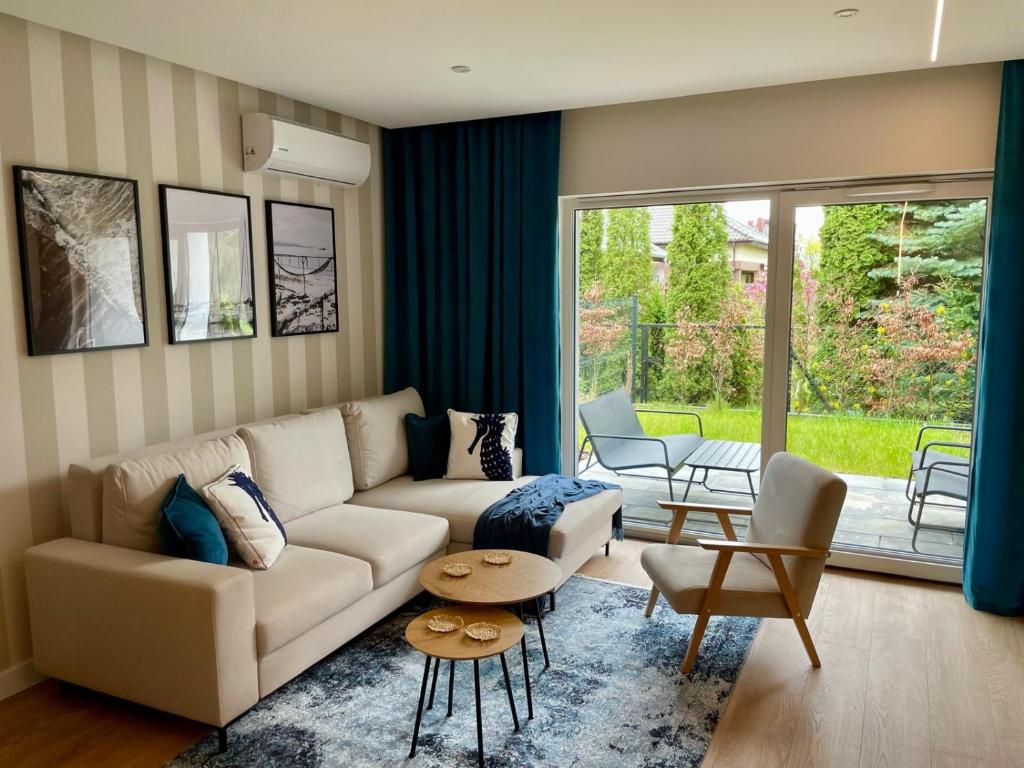 uma sala de estar com um sofá e uma mesa em Blue Apartament - HOME APART em Ostróda