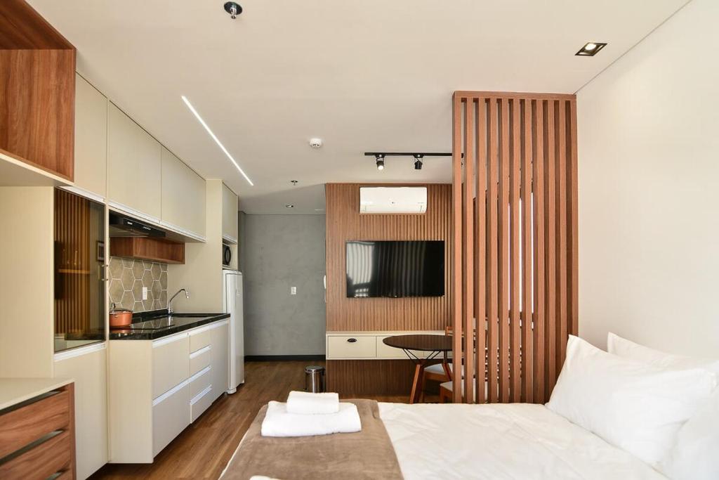 a bedroom with a bed and a small kitchen at BHomy Perdizes - Piscina com vista de Sampa VA410 in Sao Paulo