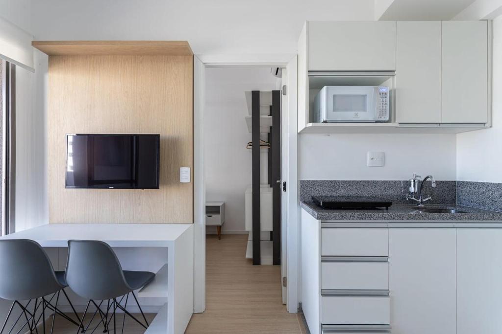 a kitchen with a table and chairs and a microwave at BHomy V Nova Conceicao - Suíte e varanda NX1409 in Sao Paulo