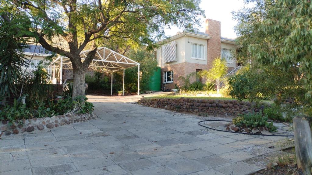 a driveway in front of a house with a tree at Uitzight in Beaufort West
