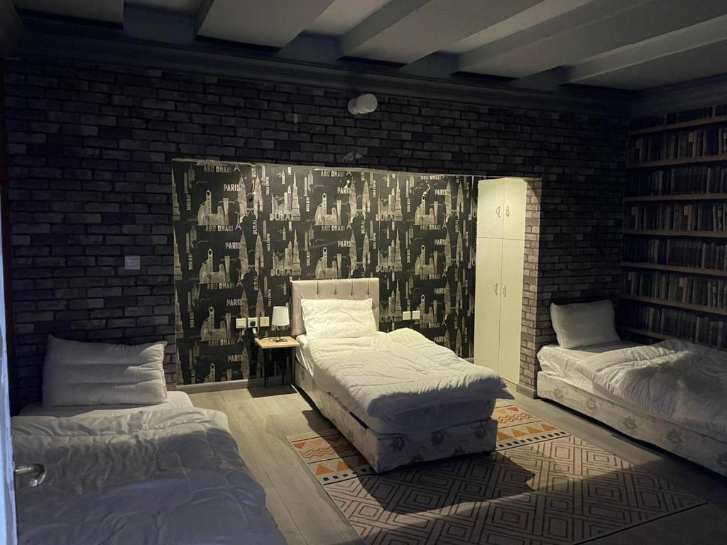 a bedroom with two beds and a brick wall at شقق 5د من الحرم النبوي Apartments 5mins near Masjid Nabawi in Al Madinah