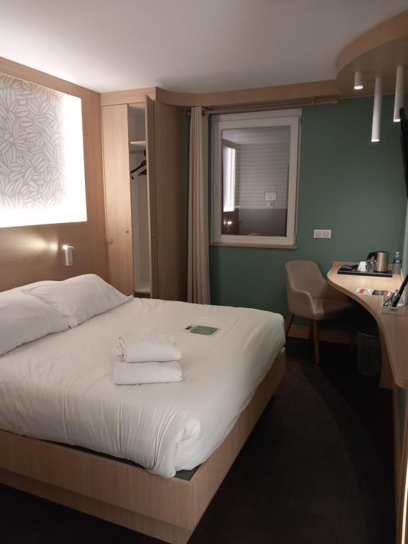 Postel nebo postele na pokoji v ubytování Hôtel Aster Restaurant Aux Arcades
