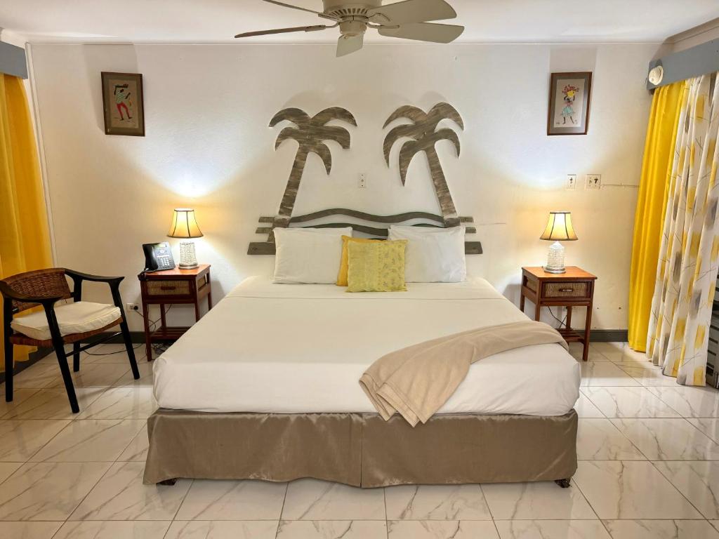 a bedroom with a large bed with palm trees on the wall at Cecille's Gardens in Cardiff Hall