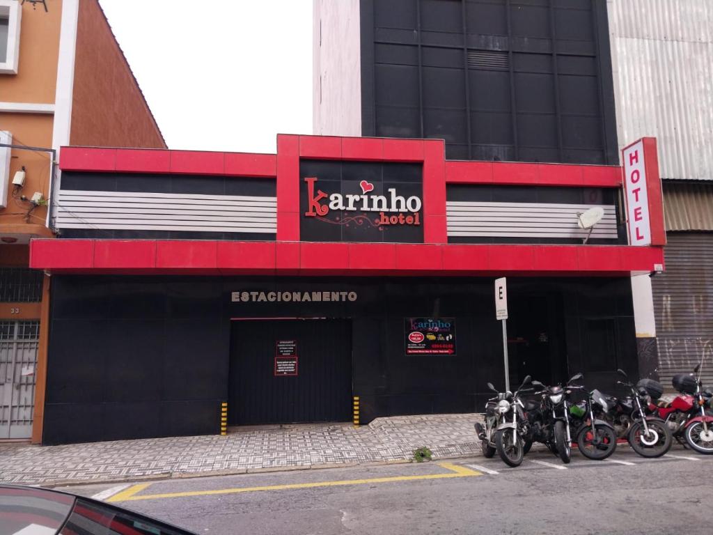 un gruppo di motocicli parcheggiato di fronte a un edificio di Karinho Hotel a Santo André