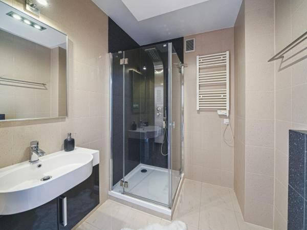 een badkamer met een glazen douche en een wastafel bij APART NOSAL in Zakopane
