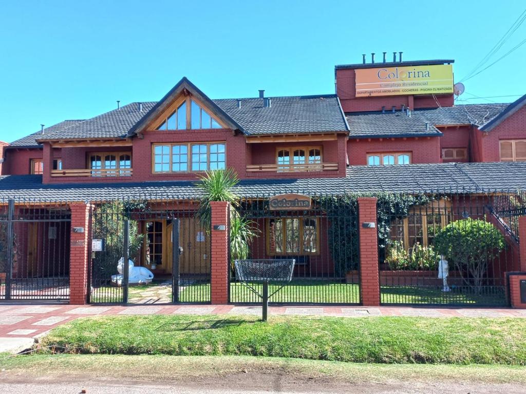 un edificio de ladrillo rojo con una puerta delante de él en Colorina Complejo Residencial en San Rafael