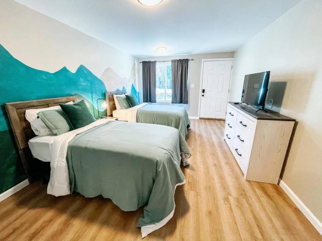 a bedroom with two beds and a flat screen tv at Mountain Room At The Trailblazer Unit 16 in Townsend