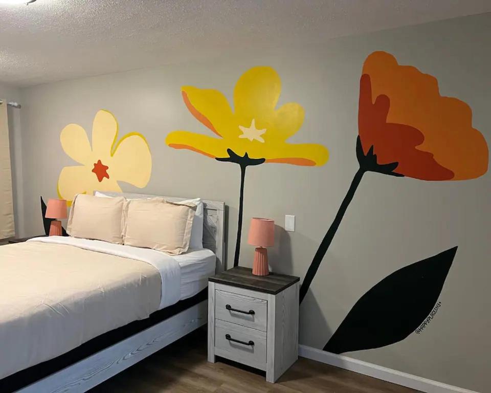 een slaapkamer met een bed met bloemen op de muur bij Wildflower Room At The Trailblazer Unit 13 in Townsend