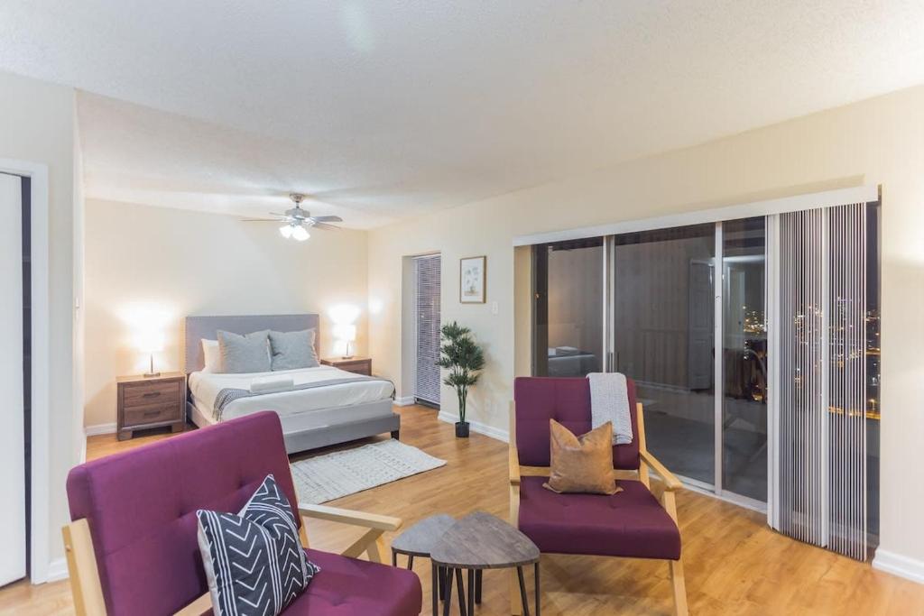 een slaapkamer met een kingsize bed en paarse stoelen bij Affordable Memphis Apartment Near Top Restaurants in Memphis