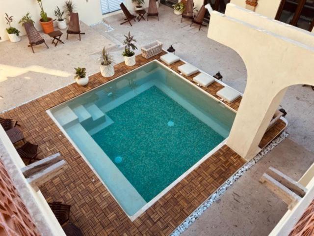 een uitzicht op een zwembad met stoelen en een patio bij Casa Victoria Malecon in Puerto Vallarta