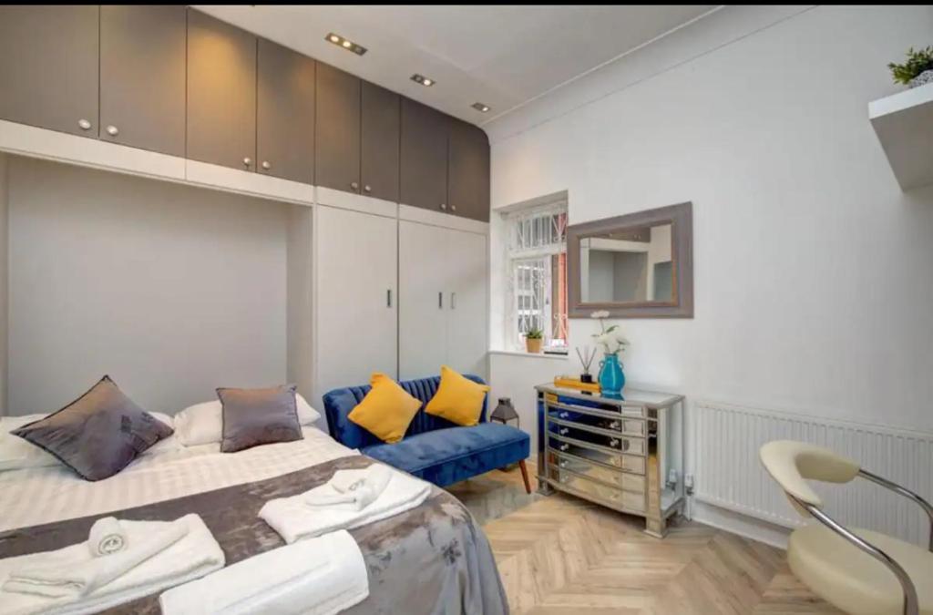 ein Schlafzimmer mit einem Bett und einem blauen Sofa in der Unterkunft Charming studio in London