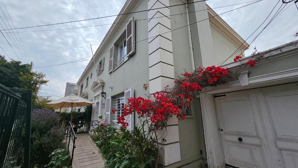 una casa con flores rojas a un lado. en Hostal Casona del Mar, en Viña del Mar