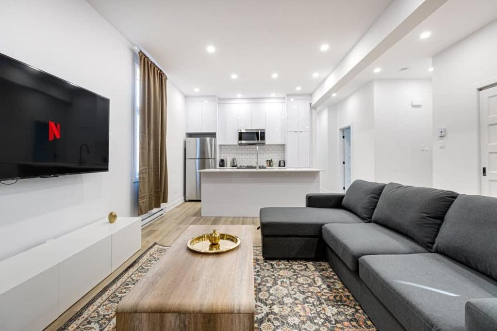 Sala de estar con sofá gris y mesa en Modern & Bright 3BR with Sofabed in Mile-End, en Montreal