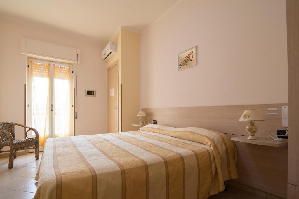 una camera con letto, tavolo e finestra di Albergo Bed and breakfast FLORIDA a Capo Rizzuto