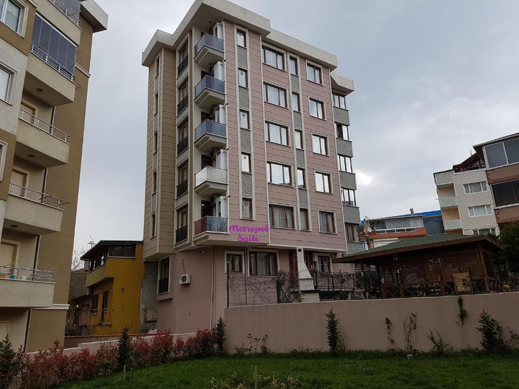 wysoki budynek apartamentowy z fioletowym znakiem w obiekcie Metropol suite w Stambule