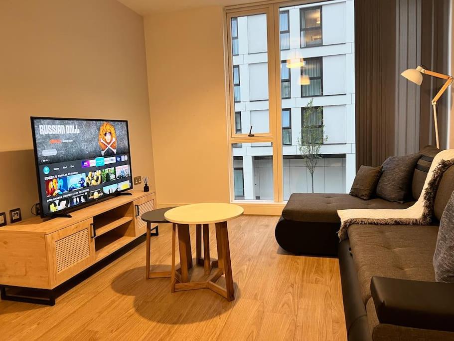 a living room with a couch and a table and a tv at Lovely 2 bedroom Apartment in Central Manchester in Manchester