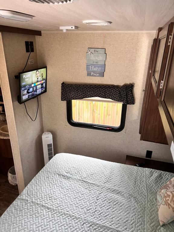 ein Schlafzimmer in einem Wohnwagen mit einem Bett und einem TV in der Unterkunft RV Paradise on the Wheels at Clearwater Beaches in Largo