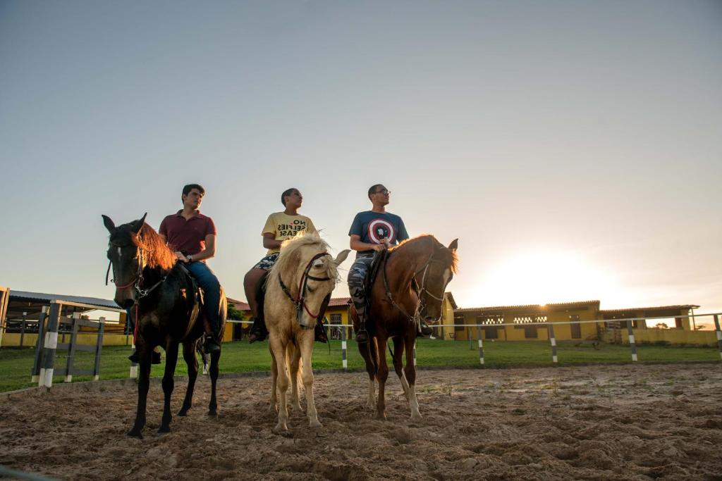 un groupe de personnes à cheval sur un champ de terre dans l'établissement Hotel Fazenda Mirage, à Feira de Santana