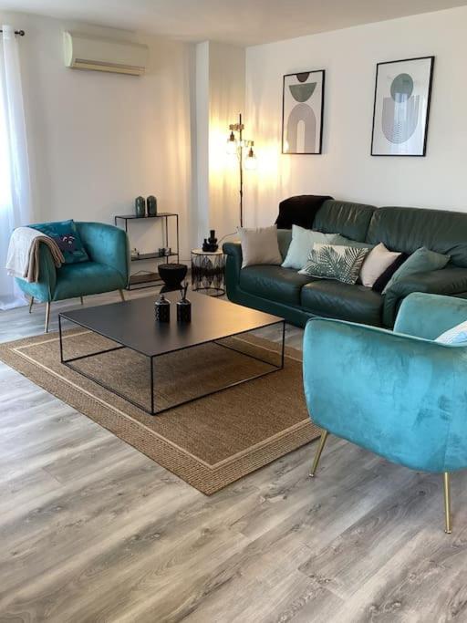 un salon avec un canapé bleu et une table dans l'établissement La Casa d'Isabelle, Charme Corse à Patrimonio, à Patrimonio