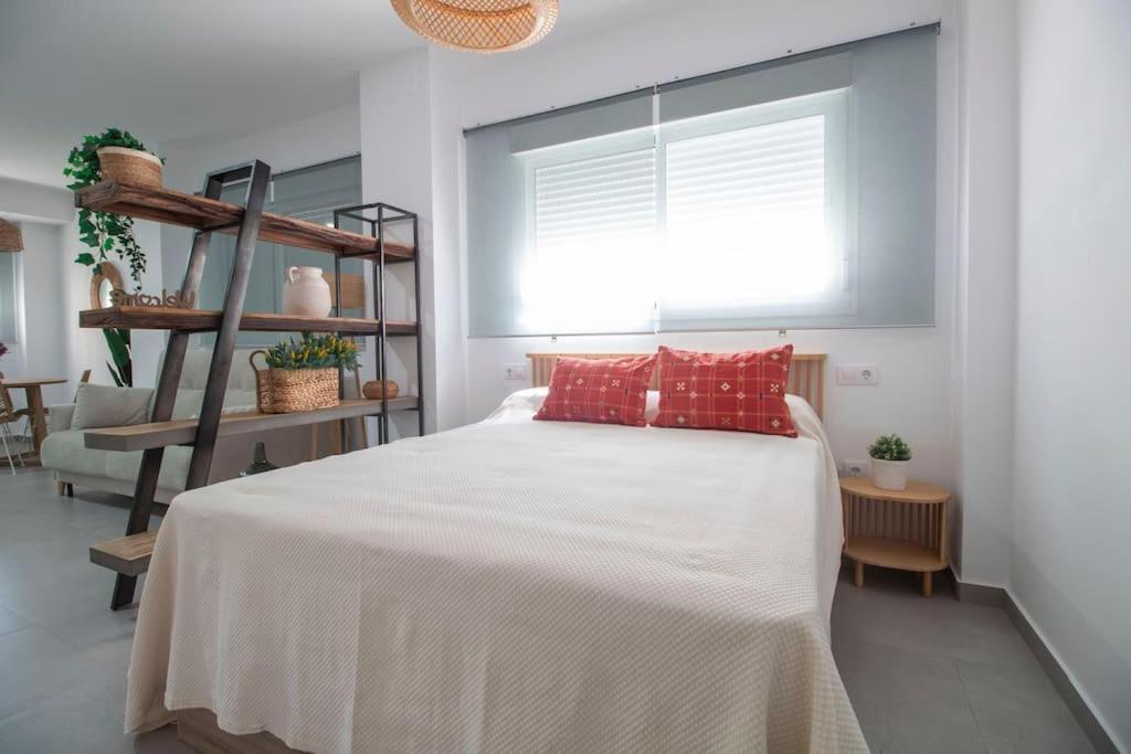 1 dormitorio con 1 cama blanca grande con almohadas rojas en Tartessos Apartamentos 1 en Sevilla