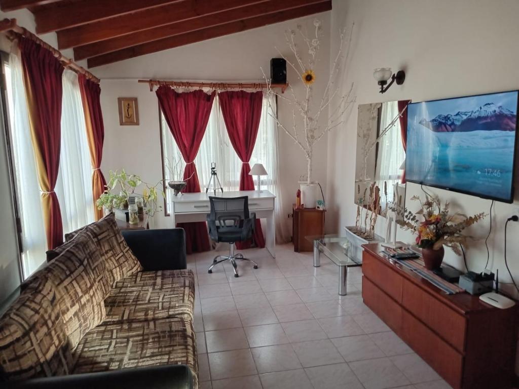 uma sala de estar com um sofá e uma televisão de ecrã plano em Para Toda la Familia em Puerto Madryn