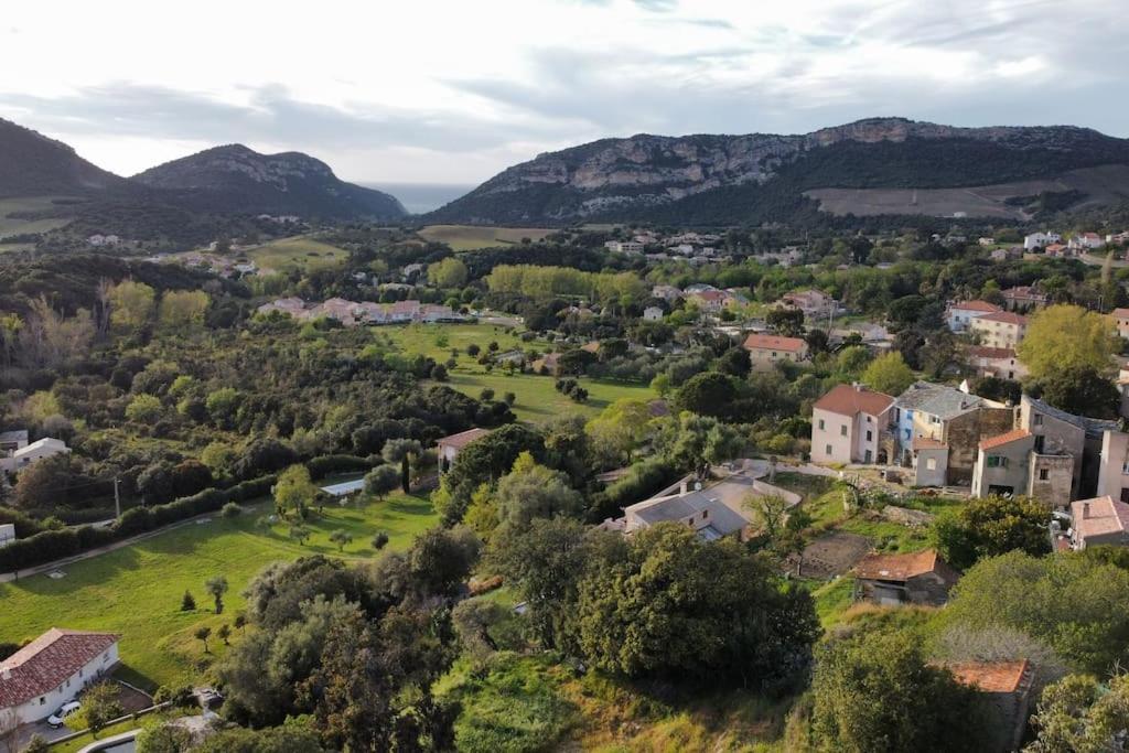 una vista aerea di un piccolo villaggio in montagna di La Casa d'Isabelle, Charme Corse à Patrimonio a Patrimonio