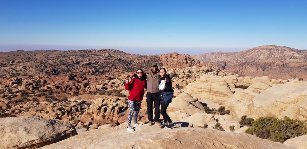three people standing on the edge of a canyon at family home Lodge in Dana