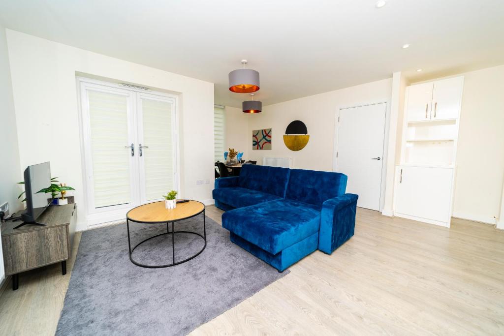 een woonkamer met een blauwe bank en een tafel bij Stunning 4 bed house near stadium and green park in Reading