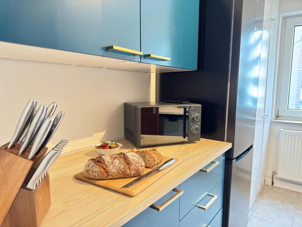 a table with two loaves of bread and a microwave at JUNX Bude in Marl