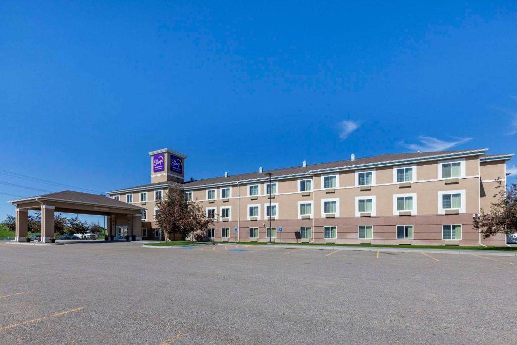 un gran edificio con un estacionamiento delante de él en Sleep Inn & Suites Idaho Falls Gateway to Yellowstone, en Idaho Falls