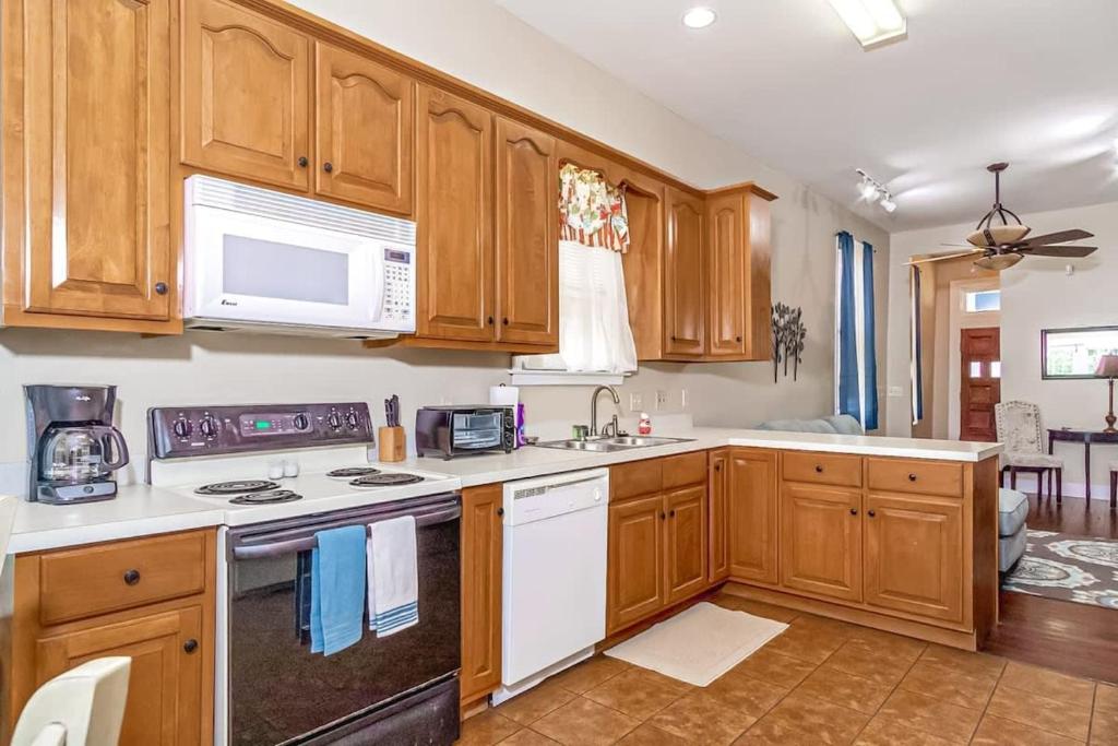 una cucina con armadi in legno e un piano cottura bianco con forno di Americana Cottage Closest Historic BnB to Benning a Columbus