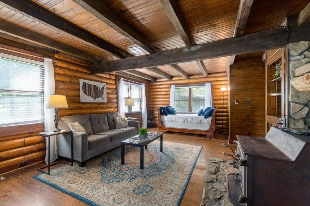 クラークスビルにあるCampbell Log Cabin! Historic Charm, Modern Luxuryのリビングルーム(ソファ、テーブル付)