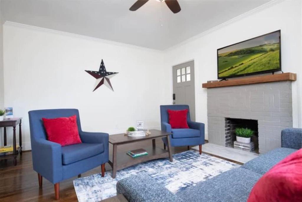 a living room with two blue chairs and a fireplace at Norwood Nugget-Tee Off at Top Golf, Historic Charm in Birmingham