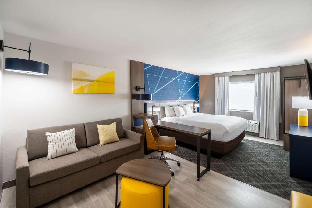 une chambre d'hôtel avec un lit et un canapé dans l'établissement Comfort Suites Longview North, à Longview