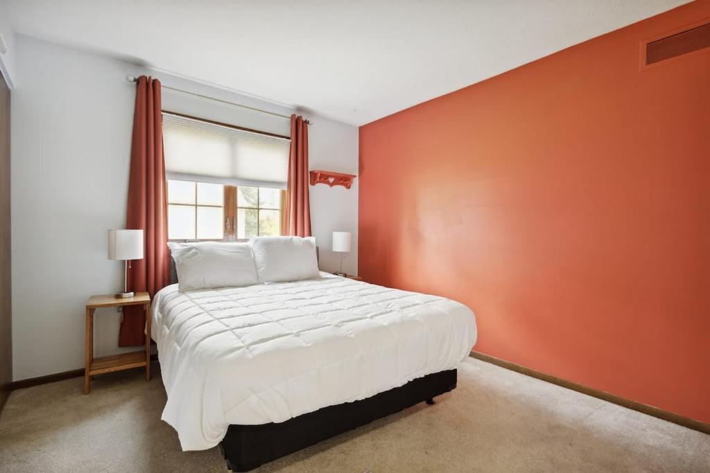 1 dormitorio con 1 cama grande y pared de color naranja en Near Shopping & Dining- The South Bend Bungalow, en Granger