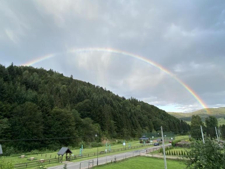 a rainbow in the sky over a road at u Faronow in Muszyna