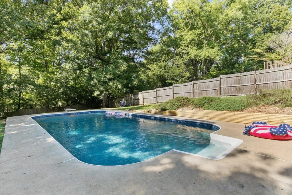 a swimming pool in a yard next to a fence at Two Kitchens Family Friendly in Forestdale in Birmingham