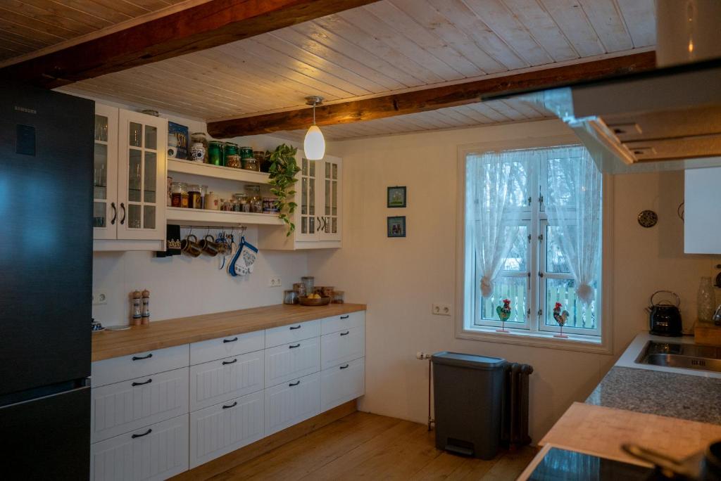 a kitchen with white cabinets and a window at Akureyri Old Town Home in Akureyri