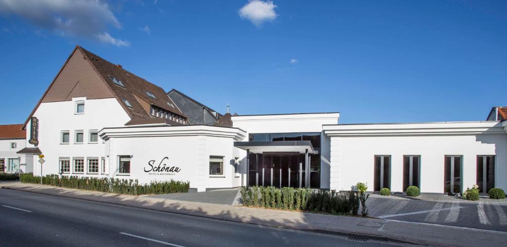 un bâtiment blanc sur le côté d'une rue dans l'établissement Hotel & Restaurant Schönau, à Peine