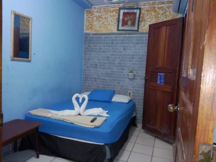 a small room with a blue bed with a towel at D' all leon hostal in León