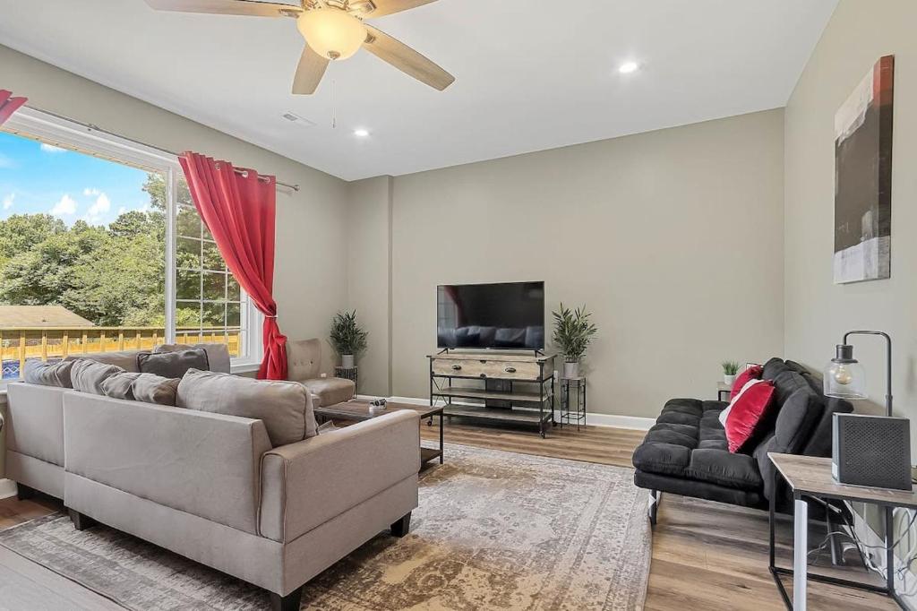 a living room with a couch and a tv at Mins to Oakwood U! American Retreat in Huntsville