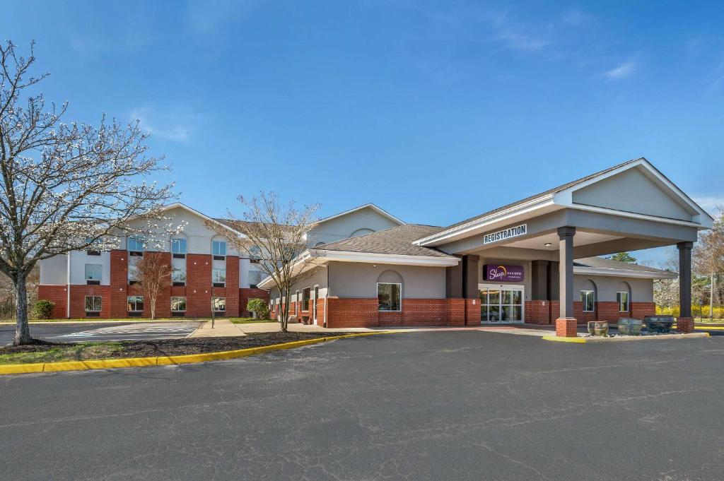 un bâtiment avec un parking en face de celui-ci dans l'établissement Sleep Inn & Suites, à Newport News