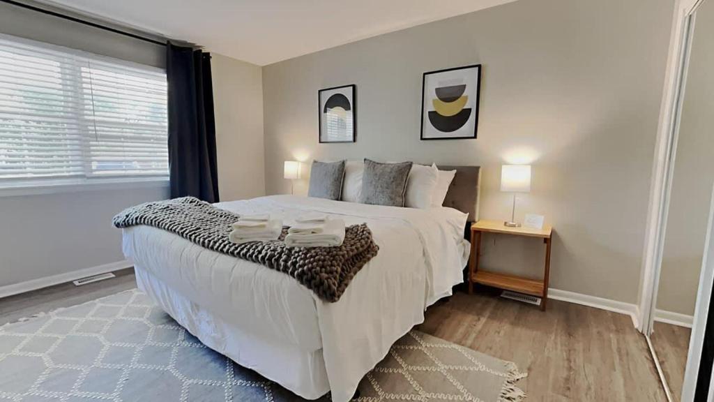 a bedroom with a large white bed and a window at Capital City Delight-Close to Speedway Downtown and easy access to Highways in Indianapolis
