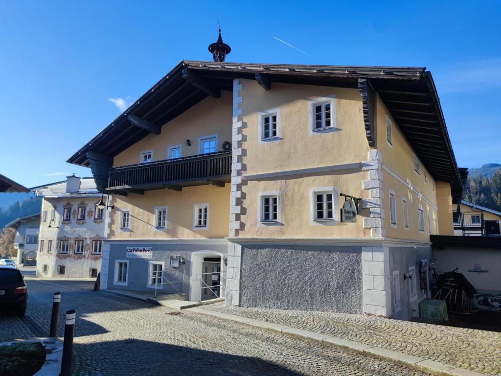 un grand bâtiment jaune avec un toit noir dans l'établissement Zentral, à Hopfgarten im Brixental