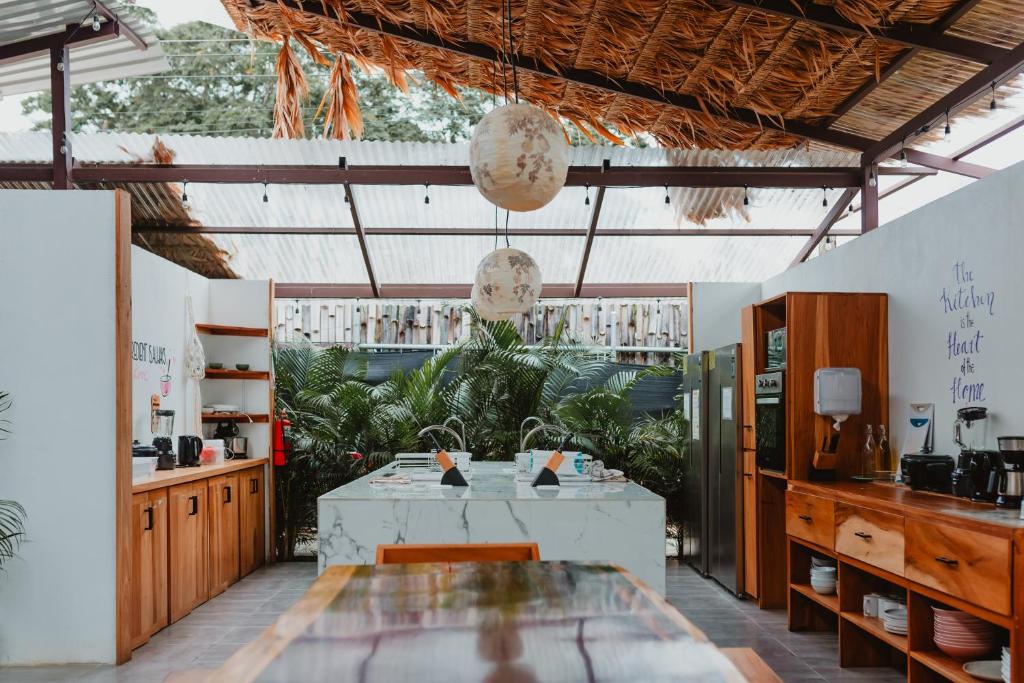 una cocina con mesa y algunas plantas en La Tribu Boutique Hostel for women en Puerto Viejo