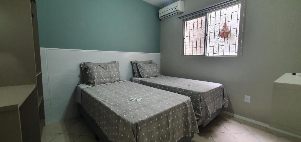1 dormitorio con 2 camas y ventana en Murilo House en São José