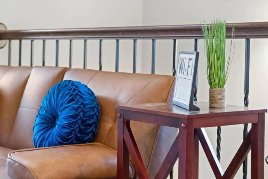 un sofá marrón sentado sobre una mesa junto a una mesa con un azul en The Campbell Carriage House, en Clarksville